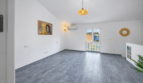 Helles, leeres Wohnzimmer mit grauem Fliesenboden, Klimaanlage, Pendelleuchte und Kunstwerk im Stadthaus Felanitx