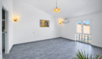 Helles, leeres Wohnzimmer mit grauem Fliesenboden, Wandleuchten, Klimaanlage und Stierbild in Felanitx