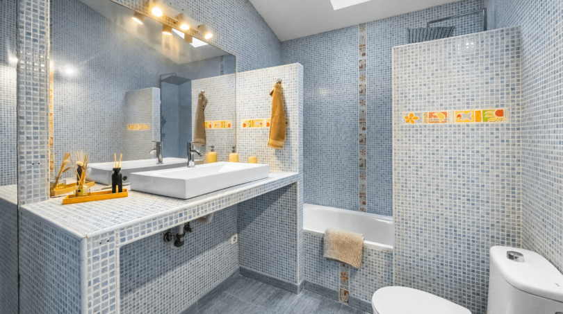 Modernes Badezimmer mit blauem Mosaikfliesenspiegel, Einbaubadewanne und Dachfenster im Stadthaus Felanitx