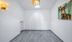 Leerer Wohnraum mit grauem Fliesenboden, Wand-Eselgemälde, Skylight und Rattanlampen im modernen Stadthaus Felanitx