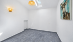 Helles, leeres Zimmer mit Dachfenster, Pendelleuchte, Wandlampe und Esel-Kunstwerk in modernem Stadthaus Felanitx