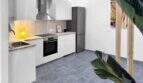 Moderne weiße Küche mit Einbauofen, Induktionskochfeld, Edelstahlkühlschrank und grauem Fliesenboden im Stadthaus Felanitx