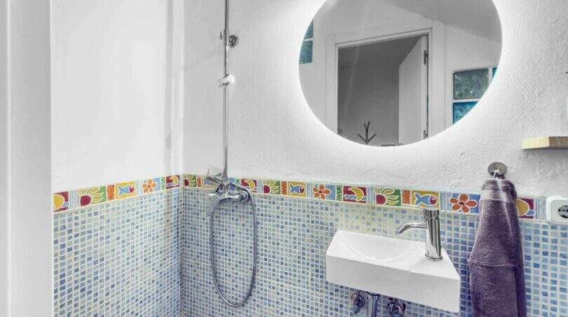Modernes Badezimmer mit blauem Mosaikfliesen, buntem Bordürendekor, Regendusche und beleuchtetem Rundspiegel in Stadthaus Felanitx