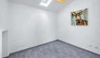 Helles, leeres Zimmer mit Dachfenster, grauem Vinylboden und Eselsgemälde an weißer Wand in Felanitx