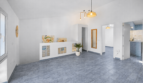 Helles Wohnzimmer mit grauem Fliesenboden, weißen Wänden, Glasbausteinwand und moderner Pendelleuchte in Felanitx