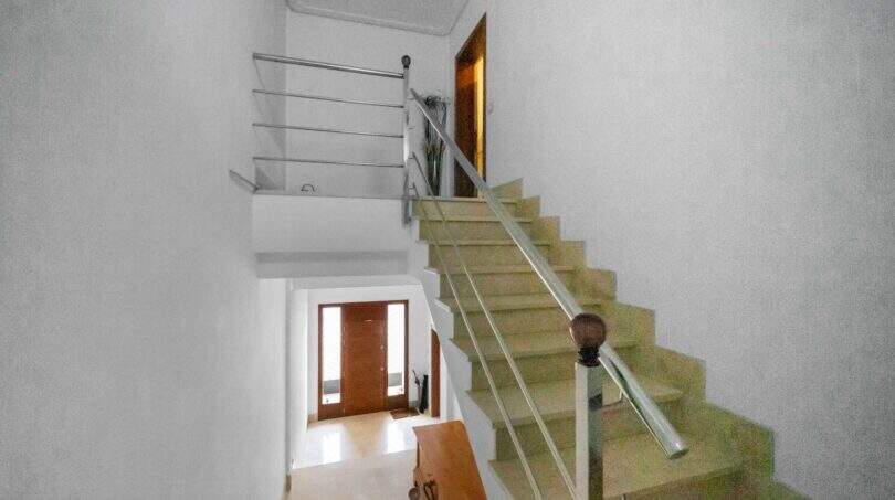Bright stairwell with modern chrome railing and glass balustrade in house in Felanitx