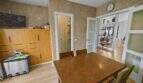 Dining room with wooden table, built-in wardrobe and passage to living area in house in Felanitx