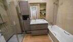 Modern bathroom with glass shower, built-in wardrobe, double sink and bathtub in house in Felanitx