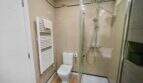 Modern bathroom with glass shower, toilet and towel radiator in house in Felanitx