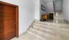 Bright stairwell with marble staircase, wooden door and wooden dresser in the house in Felanitx