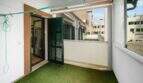 Covered balcony with artificial grass, green shutters and view of inner courtyard in Felanitx
