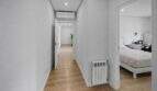 Bright hallway with wooden floor, radiator and view into modern bedroom in house in Felanitx