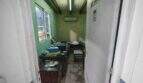 Small, untidy office room with green walls, wooden beams, air conditioning and desk in house Felanitx
