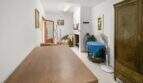 Living room with wooden table, fireplace, cupboard and fan in the charming 1900 townhouse in Felanitx