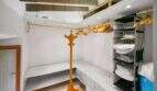 Spacious dressing room with gold clothing rail, wardrobe stand and fabric shelf with towels in the Felanitx townhouse