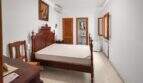 Bedroom with antique wooden bed, en-suite bathroom, air conditioning and radiator in the 1900 town house in Felanitx