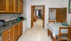 Kitchen with wooden cabinets, granite worktop and adjacent dining area in the historic townhouse in Felanitx