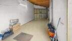Spacious garage with wooden beam ceiling, tiled floors and roller door in the charming townhouse in Felanitx.