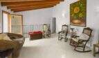 Living area in the Felanitx townhouse with wooden beam ceiling, rocking chairs and sunflower painting