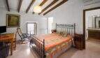 Bedroom with double bed, wooden beam ceiling, balcony and en-suite bathroom in the 1900 townhouse in Felanitx