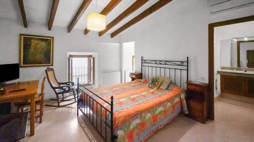 Bedroom with double bed, wooden beam ceiling, balcony and en-suite bathroom in the 1900 townhouse in Felanitx