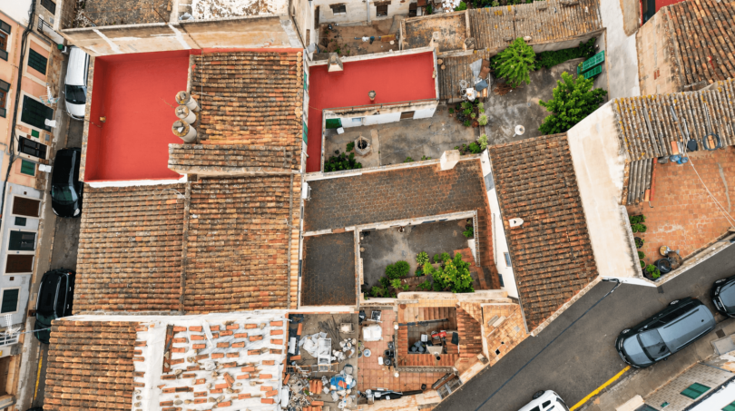Aerial view historic townhouse Felanitx, terracotta roof, red terrace, courtyard with greenery, garage visible