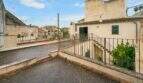 Roof terrace of the historic townhouse in Felanitx with metal railing, stairway and view of the old town.