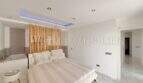 Helles Schlafzimmer im Penthouse Cala Pi mit Doppelbett, Bambus-Raumteiler, Badewanne und LED-Deckenbeleuchtung.