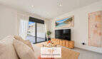 Helles Wohnzimmer des Penthouses in Colonia de Sant Jordi mit TV, Naturmaterialien und Zugang zur Dachterrasse