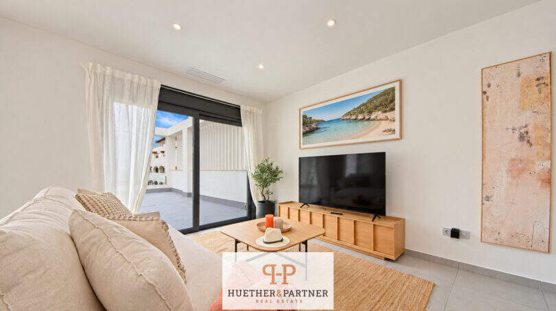 Helles Wohnzimmer des Penthouses in Colonia de Sant Jordi mit TV, Naturmaterialien und Zugang zur Dachterrasse