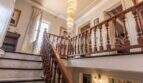 Elegantes Treppenhaus der Villa in Marratxí mit Holzgeländer, Marmorstufen und prächtigem Kristallleuchter