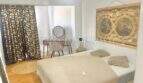 Helles Schlafzimmer mit Doppelbett, Holzboden, Weltkarte-Wandbild und elegantem Vorhang in renovierter Wohnung Palma