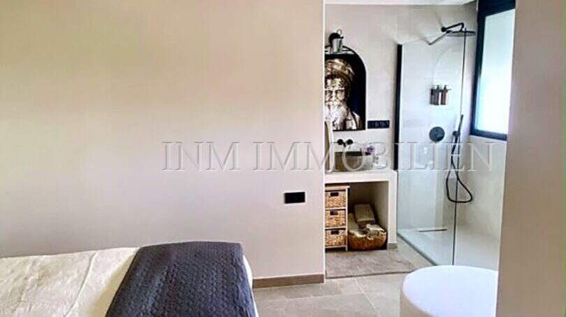 Modernes Schlafzimmer mit Deckenventilator und offenem Badbereich mit Regendusche und freistehender Badewanne