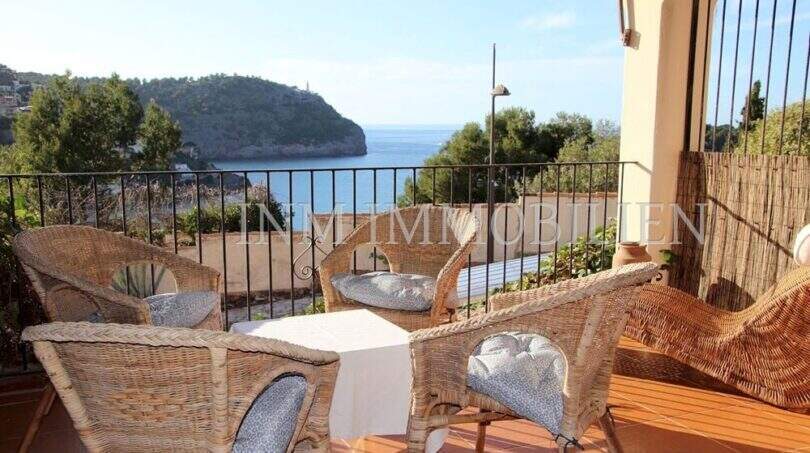 Sonnige Terrasse mit Rattanmöbeln und atemberaubendem Meerblick auf die Bucht von Port de Sóller