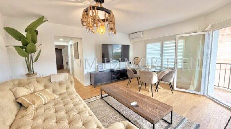 Helles Wohnzimmer mit Tufting-Sofa, Holzcouchtisch, TV-Bereich und Balkonzugang in renovierter Wohnung Playa de Palma