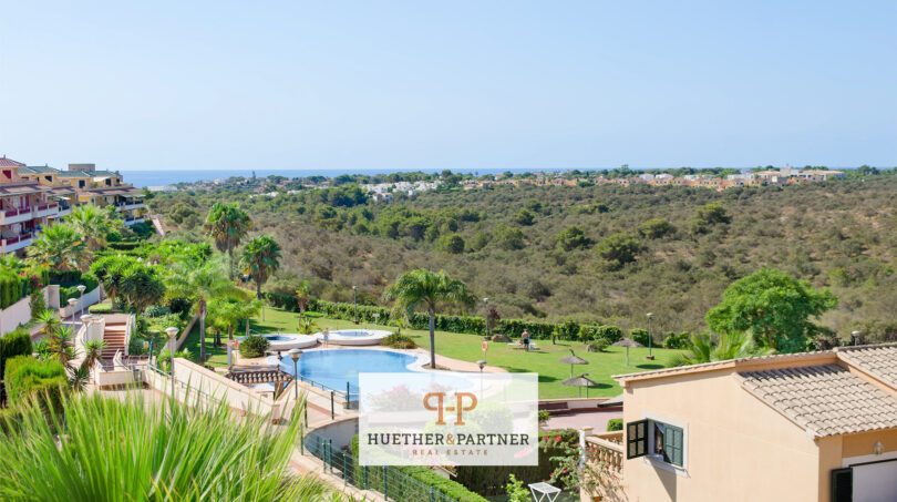 Poolanlage einer Wohnanlage in Cales de Mallorca mit Meerblick, umgeben von mediterraner Vegetation