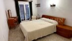 Schlafzimmer der Meereslinie-Wohnung in El Arenal mit Doppelbett, Holzmöbeln und Balkonzugang