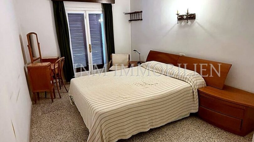 Schlafzimmer der Meereslinie-Wohnung in El Arenal mit Doppelbett, Holzmöbeln und Balkonzugang