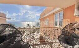 Sunny rooftop terrace with rattan furniture and direct sea view of Playa de Palma, Mallorca.