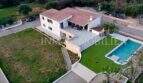 Aerial view of a white finca in Campos with terracotta roof, outdoor pool and well-maintained garden.