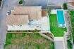Aerial view of a finca in Campos with terracotta roof, rectangular outdoor pool, lawn and palm trees.