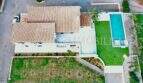Aerial view of a finca in Campos with terracotta roof, rectangular outdoor pool, lawn and palm trees.