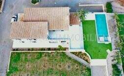 Aerial view of a finca in Campos with terracotta roof, rectangular outdoor pool, lawn and palm trees.
