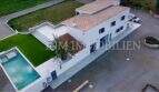 Aerial view of a white finca in Campos with outdoor pool, terracotta roof, terrace and well-maintained garden.