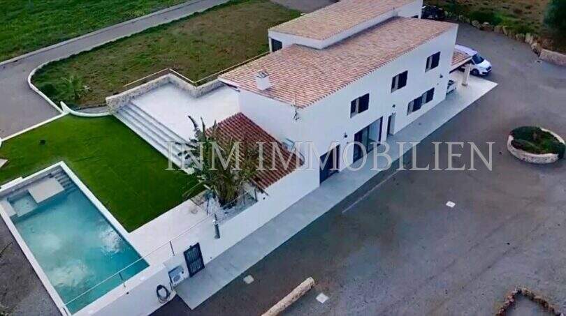 Aerial view of a white finca in Campos with outdoor pool, terracotta roof, terrace and well-maintained garden.