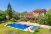 Finca near Campos: stone house with blue pool, loungers and lush greenery under blue sky.