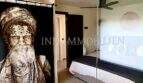 Stilvoles Schlafzimmer mit Kunstwerk-Vorhang, weißem Hocker und Deckenventilatoren im Penthouse Playa de Palma