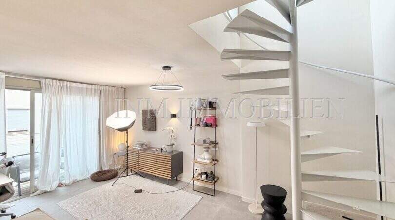 Helles Wohnzimmer der Maisonette mit weißer Wendeltreppe, modernem Sideboard und großer Terrassentür in Son Armadans