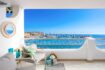 Sonnige Terrasse der Wohnung in Port Adriano mit Meerblick, Lounge-Möbeln und Blick auf den Hafen.