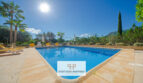 Gran piscina exterior de la finca Felanitx con tumbonas, palmeras y vistas a Sant Salvador